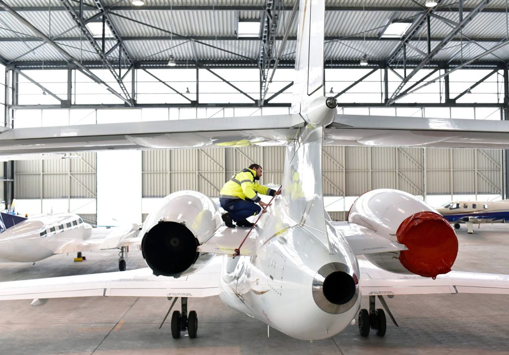 Technician performing maintenance on a business jet