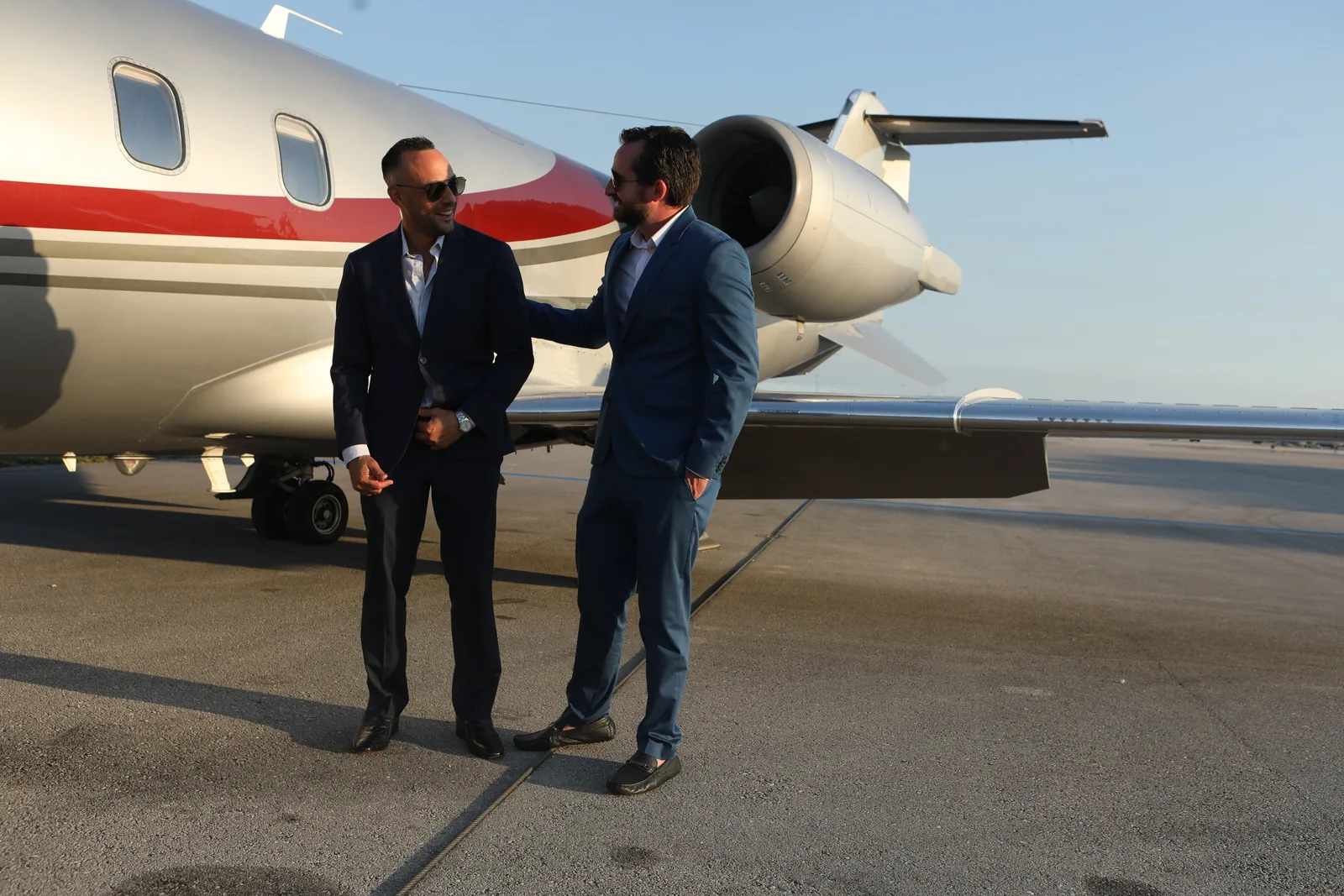 Two men shaking hands in front of a Capital Jets Learjet